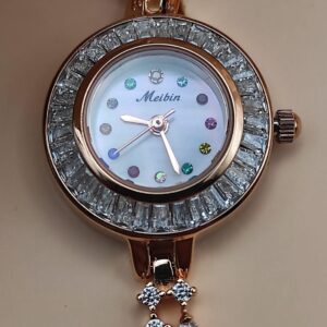 Montre Tima avec cadran blanc et index en pierres multicolores, lunette sertie de cristaux, bracelet rose gold orné de pierres décoratives, posée sur un fond de pétales beige.
